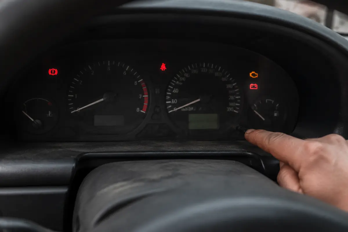 Older vehicle dashboard with an unreliable odometer and warning lights